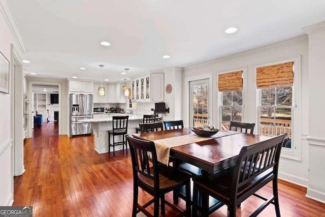 dining space with hardwood / wood-style floors and crown molding