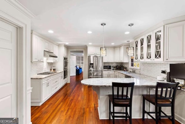 kitchen with white cabinetry, sink, dark hardwood / wood-style flooring, pendant lighting, and appliances with stainless steel finishes