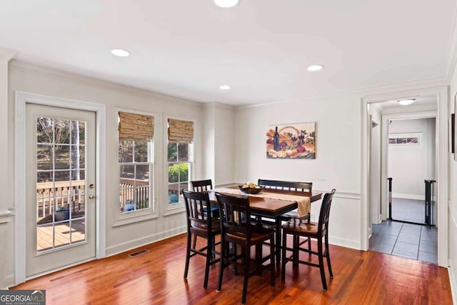 dining space with ornamental molding, hardwood / wood-style flooring, and a healthy amount of sunlight