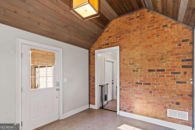 entryway with lofted ceiling, light tile patterned floors, wooden ceiling, and brick wall