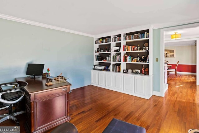 home office featuring hardwood / wood-style flooring, built in shelves, and ornamental molding