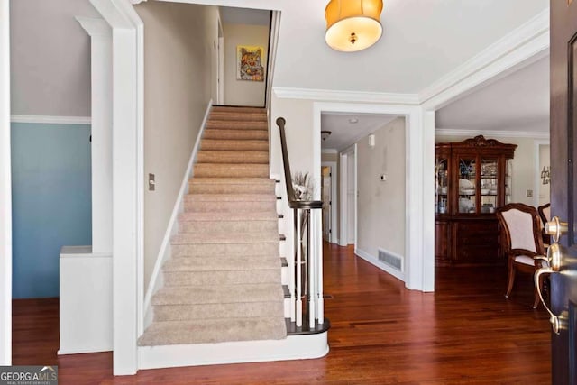 stairs with hardwood / wood-style floors and ornamental molding