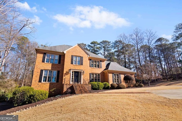 colonial inspired home featuring a front lawn