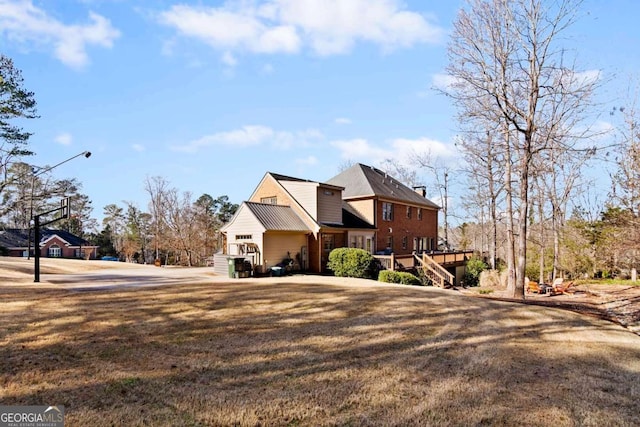 view of front of house featuring a front lawn and a wooden deck