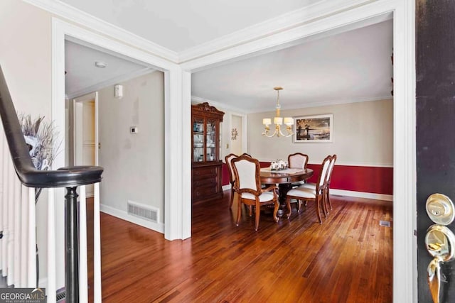 dining space featuring a chandelier, dark hardwood / wood-style floors, and ornamental molding