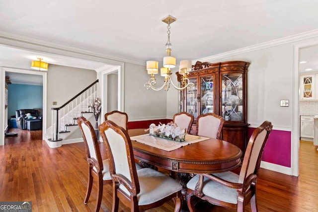 dining space featuring crown molding, hardwood / wood-style floors, and a notable chandelier