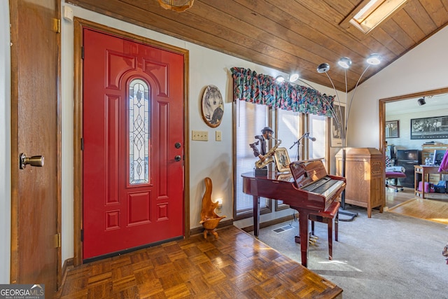 foyer entrance with wood ceiling and lofted ceiling with skylight