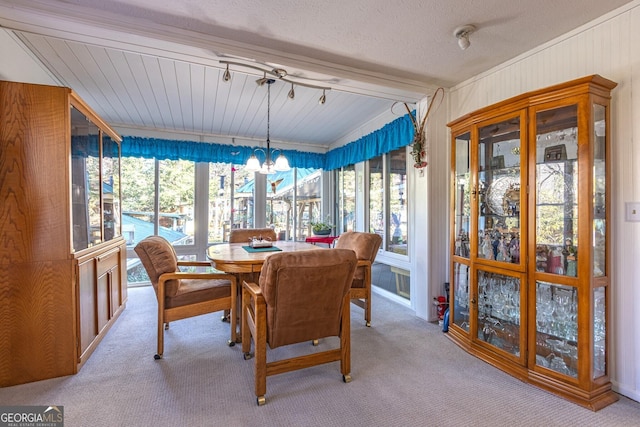 dining area featuring vaulted ceiling with beams, a wealth of natural light, light colored carpet, and an inviting chandelier