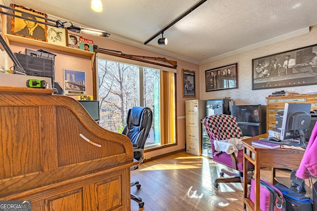 home office with hardwood / wood-style floors, a textured ceiling, rail lighting, and crown molding