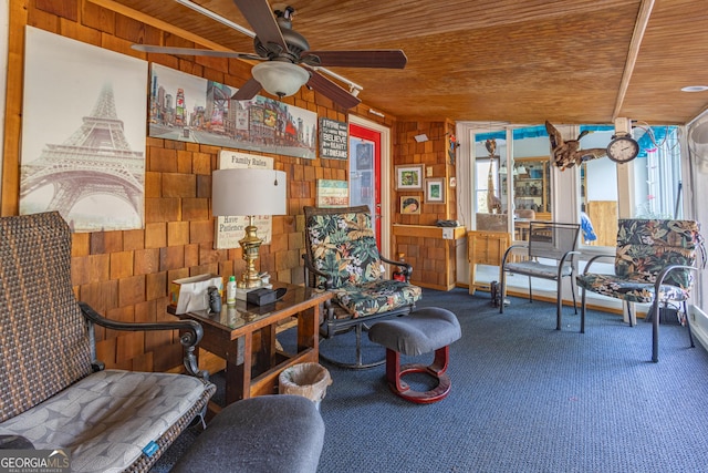 living area with carpet flooring, wooden walls, ceiling fan, and wooden ceiling