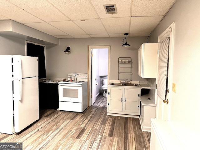 kitchen featuring a paneled ceiling, white appliances, sink, decorative light fixtures, and white cabinetry