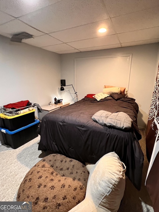 bedroom featuring a drop ceiling and carpet floors