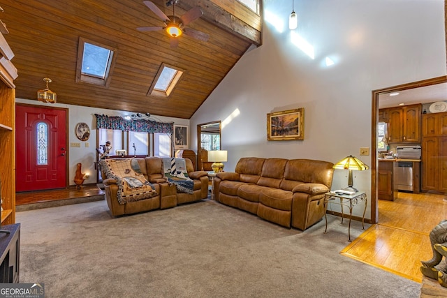 carpeted living room with high vaulted ceiling, ceiling fan, a wealth of natural light, and a skylight