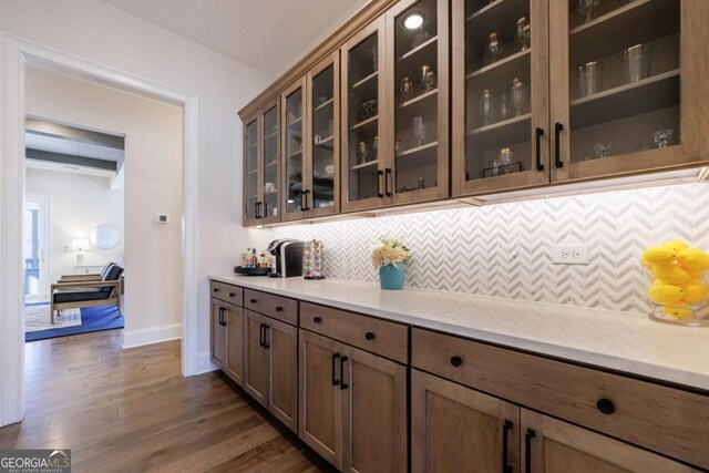 bar featuring pendant lighting, an inviting chandelier, dark hardwood / wood-style floors, tasteful backsplash, and light stone countertops