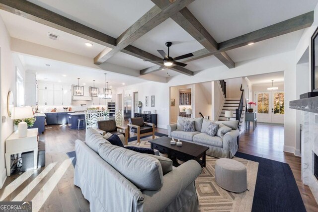 unfurnished living room featuring dark hardwood / wood-style flooring, built in shelves, a high end fireplace, and beam ceiling