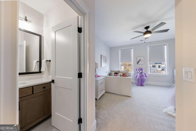 clothes washing area with sink, light tile patterned floors, washer and clothes dryer, and cabinets