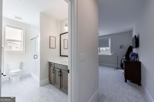 bathroom featuring vanity, tile patterned flooring, a shower with shower door, and toilet