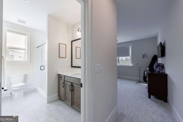 bathroom featuring vanity, an enclosed shower, and toilet