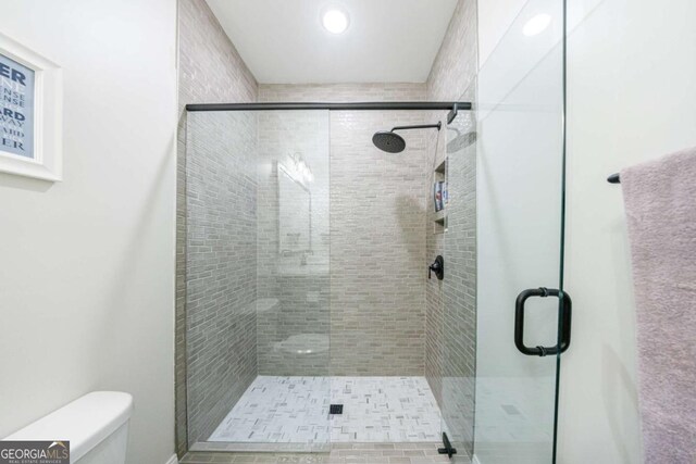 bathroom with vanity, tile patterned flooring, a shower with door, and toilet