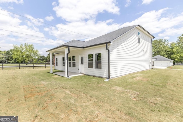 rear view of property featuring a lawn and a patio