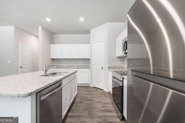 kitchen featuring appliances with stainless steel finishes, dark hardwood / wood-style floors, an island with sink, sink, and white cabinets