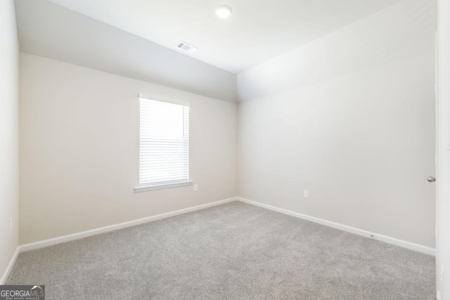 unfurnished room with light carpet and lofted ceiling