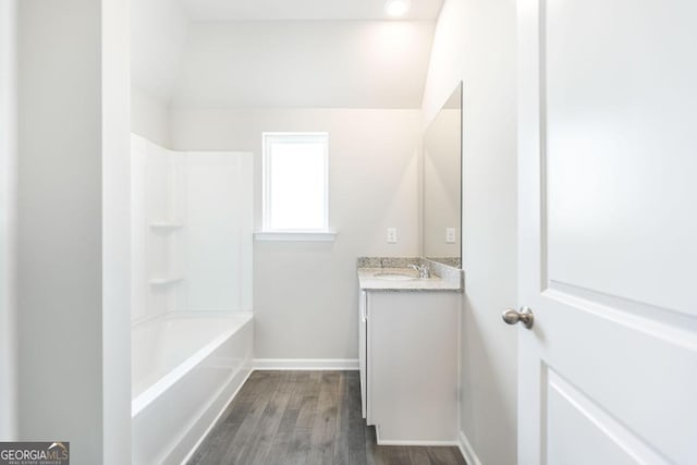 bathroom featuring wood-type flooring, bathing tub / shower combination, and vanity