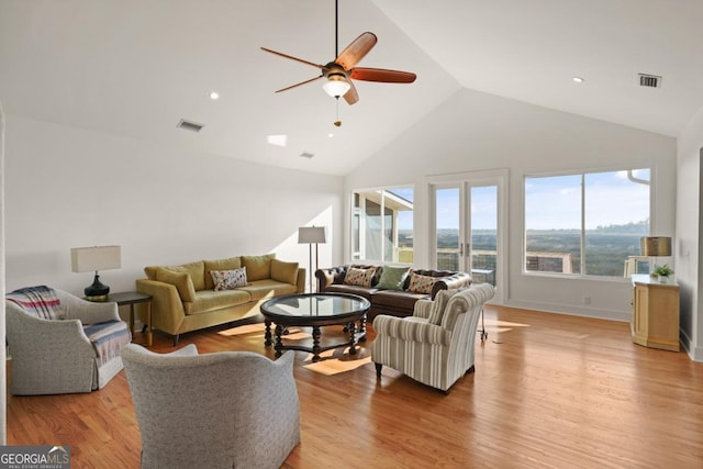 living room featuring ceiling fan, light hardwood / wood-style floors, and vaulted ceiling