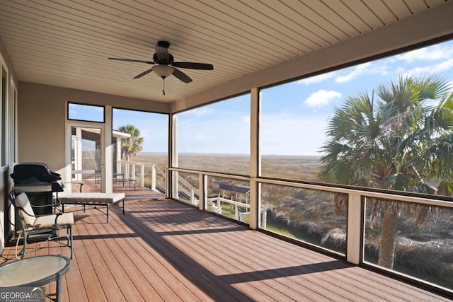 unfurnished sunroom with ceiling fan