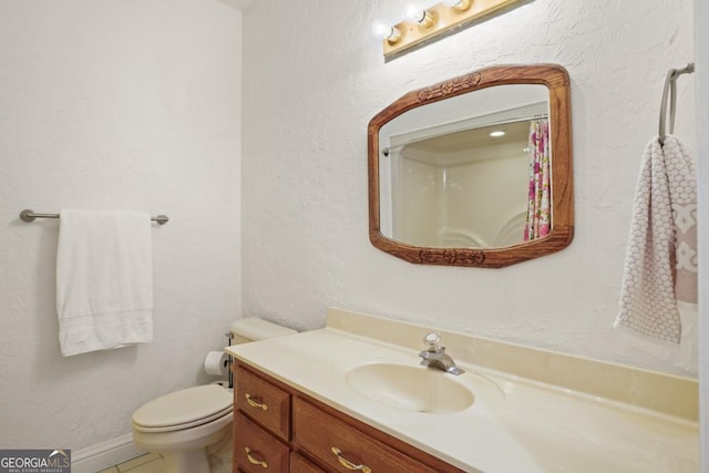 bathroom featuring tile patterned floors, vanity, and toilet