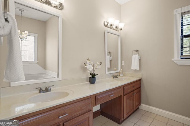 bathroom with tile patterned floors, plenty of natural light, vanity, and a notable chandelier