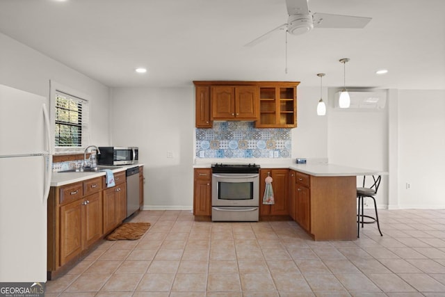 kitchen with pendant lighting, a kitchen breakfast bar, appliances with stainless steel finishes, a wall mounted AC, and kitchen peninsula