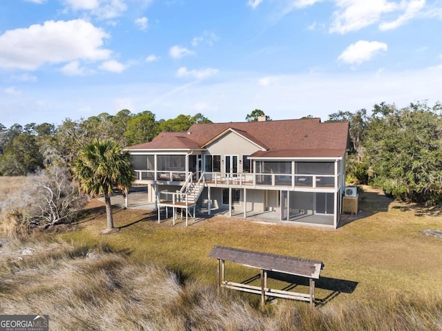 back of property featuring a patio area, a sunroom, and a yard