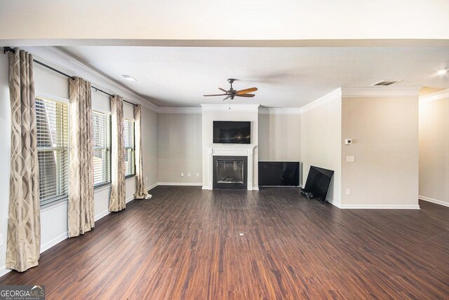 unfurnished living room with ceiling fan, crown molding, and dark hardwood / wood-style floors