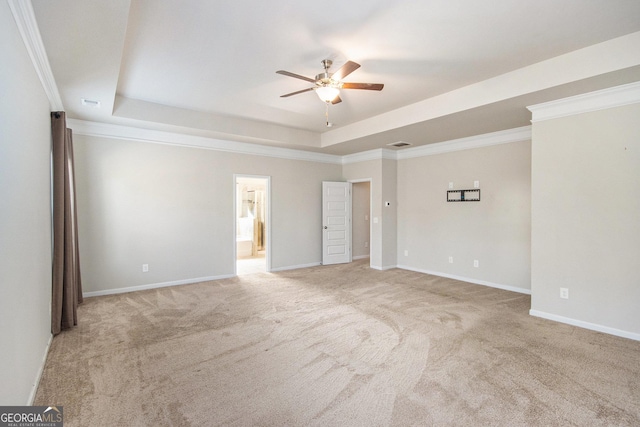 carpeted empty room featuring ornamental molding, ceiling fan, and a tray ceiling