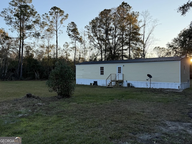 back house at dusk with a lawn