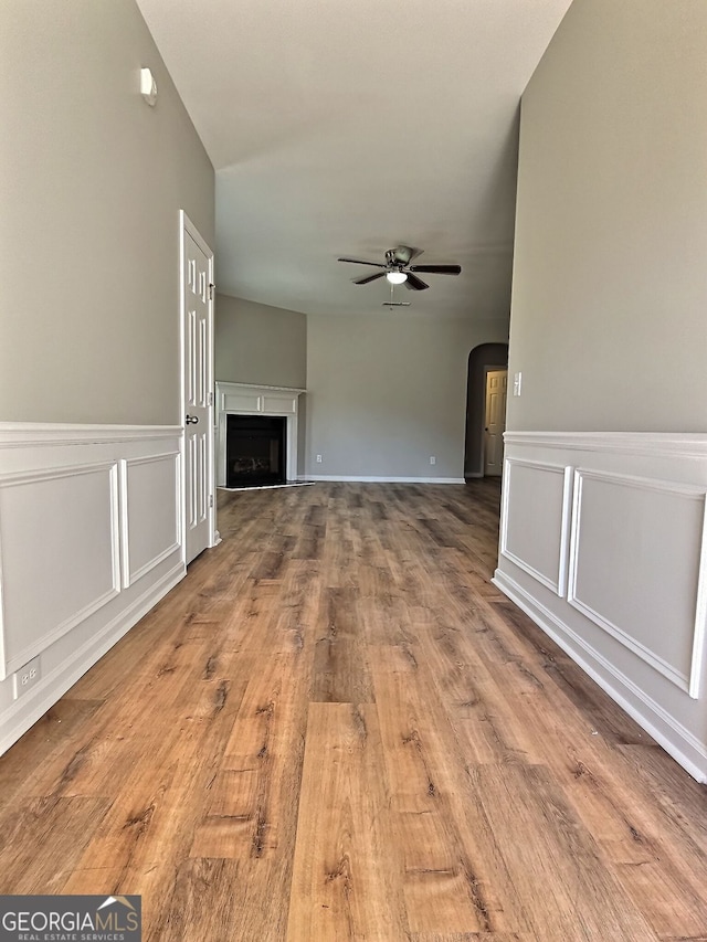 unfurnished living room with light wood-type flooring and ceiling fan