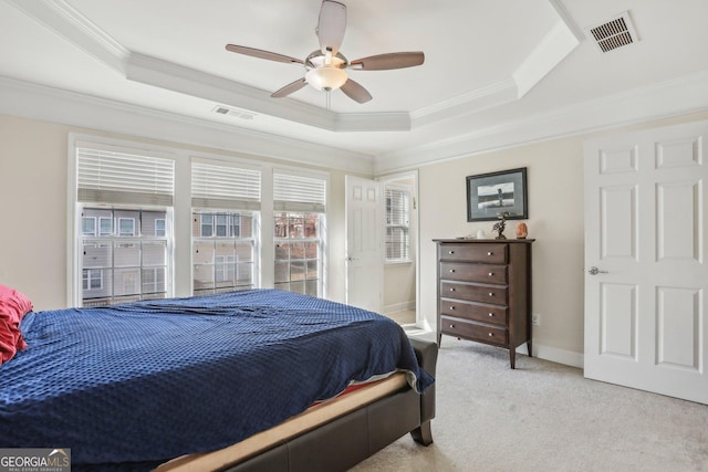 bedroom featuring light carpet, a raised ceiling, ceiling fan, and crown molding