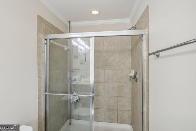 bathroom featuring a shower with shower door and ornamental molding