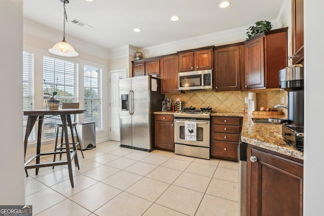 kitchen with light stone countertops, sink, hanging light fixtures, light tile patterned floors, and appliances with stainless steel finishes