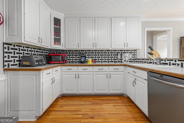 kitchen with decorative backsplash, dishwasher, white cabinets, and light wood-type flooring