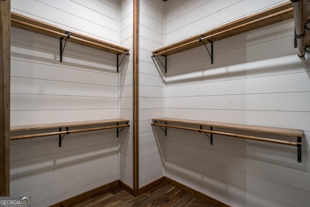 walk in closet with dark hardwood / wood-style floors