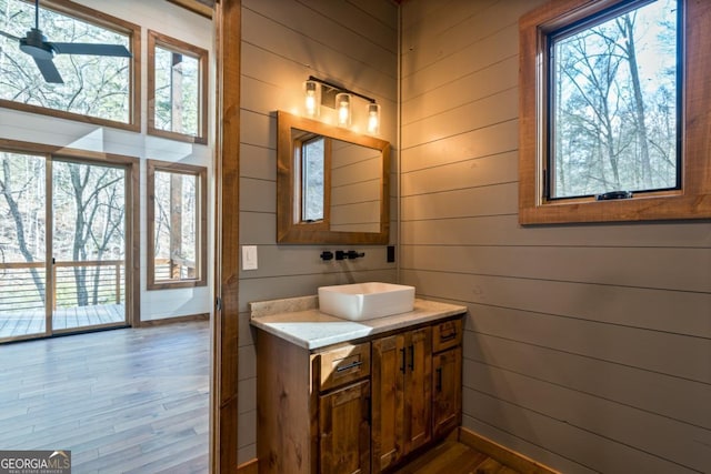 bathroom featuring vanity, wood-type flooring, and wood walls