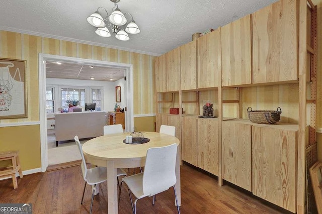 dining room with dark wood-type flooring, a textured ceiling, and a notable chandelier