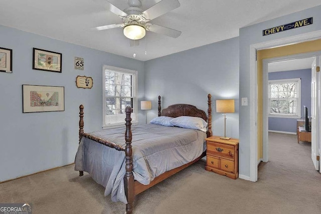 carpeted bedroom featuring multiple windows and ceiling fan