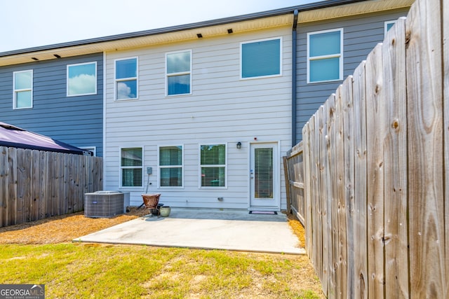 back of house with a patio, a lawn, and central air condition unit