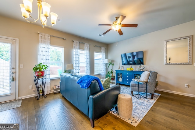 living room with ceiling fan with notable chandelier and dark wood-type flooring