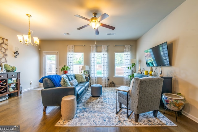 living room with ceiling fan with notable chandelier and wood-type flooring