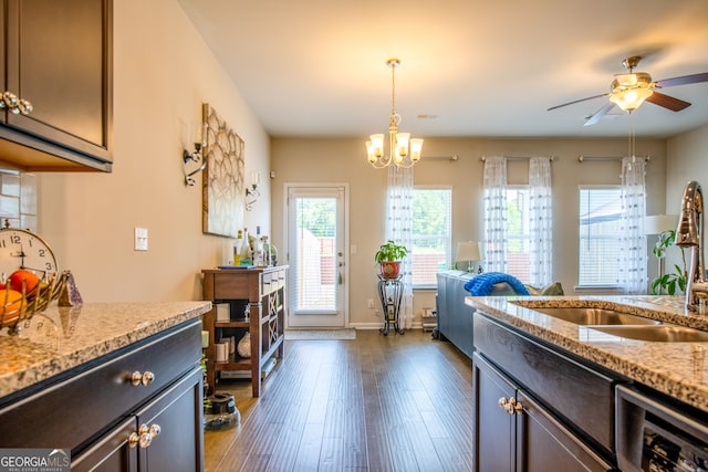 kitchen with pendant lighting, dishwasher, sink, dark hardwood / wood-style floors, and light stone countertops