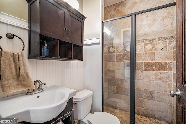 bathroom with vanity, toilet, and a shower with door